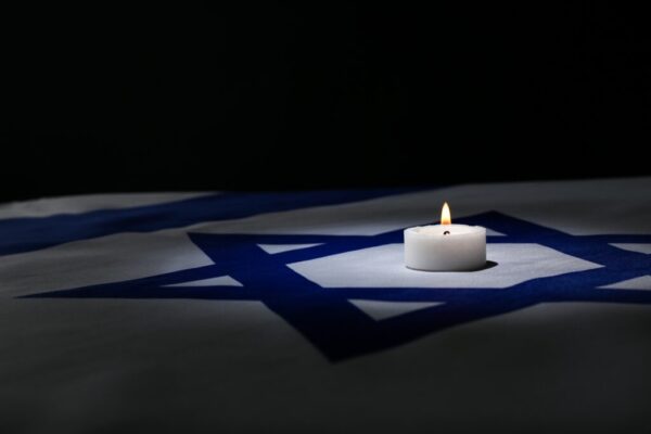 Burning,Candle,On,Flag,Of,Israel,Against,Dark,Background,With